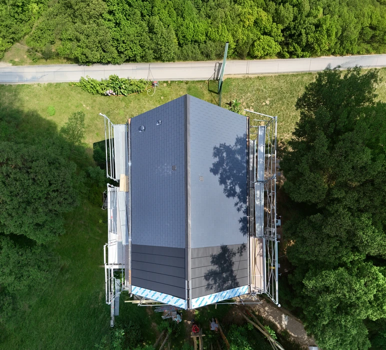 Vue aérienne d'un bâtiment en construction avec échafaudages métalliques tubulaires bilatéraux