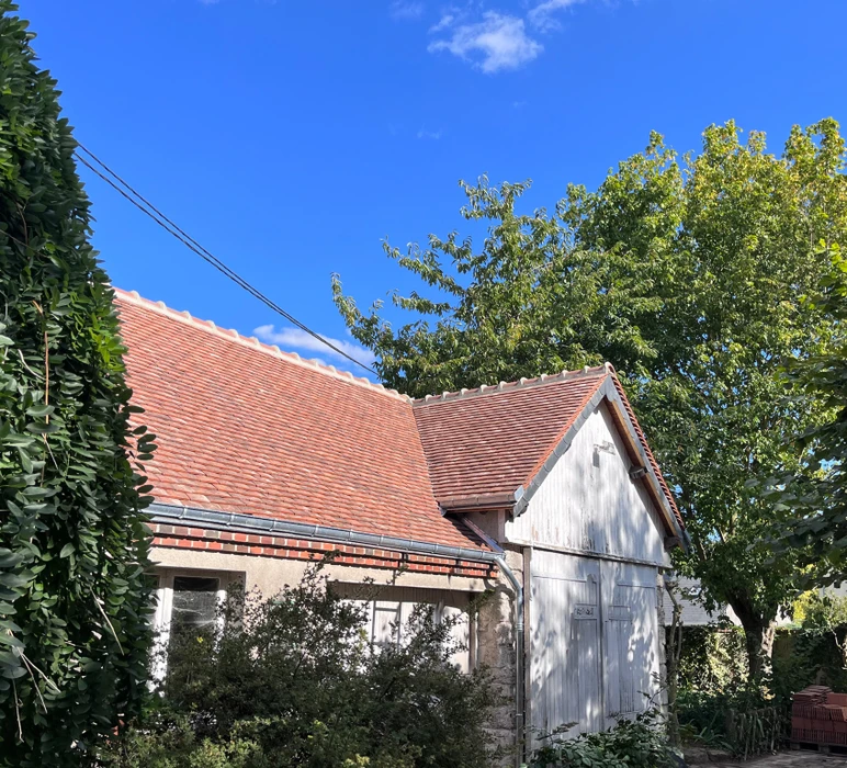 Toiture en tuiles plates de terre cuite rouge-orangé, rénovée, vue en contre-plongée