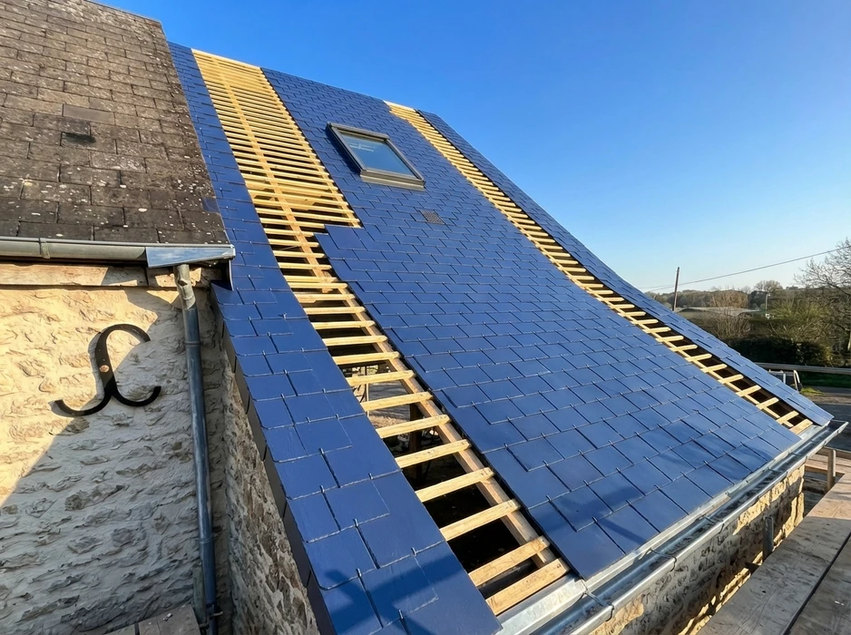 Ouvrier couvreur installant des tuiles terre cuite sur charpente bois, travaux de toiture en cours